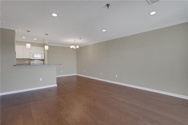 unfurnished room with ornamental molding, dark hardwood / wood-style flooring, and a chandelier