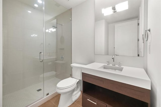 bathroom with vanity, a shower with shower door, tile patterned floors, and toilet