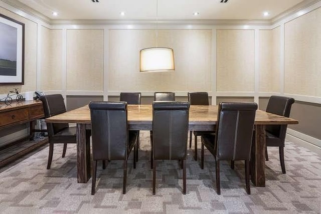 carpeted dining area with ornamental molding