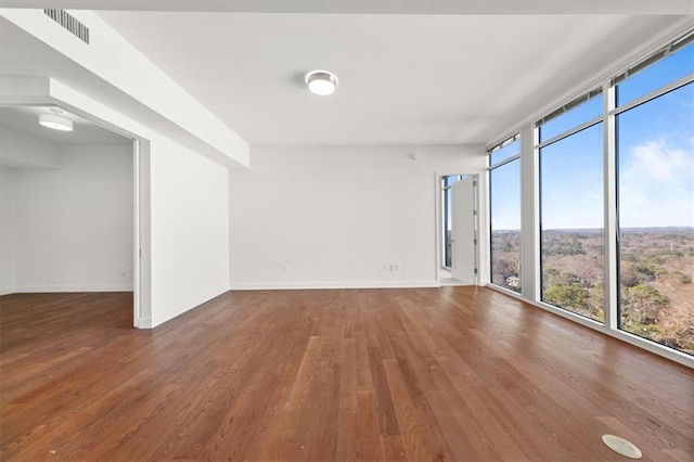 empty room featuring hardwood / wood-style floors and floor to ceiling windows