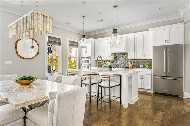 kitchen featuring dark wood-style floors, crown molding, tasteful backsplash, light countertops, and high quality fridge