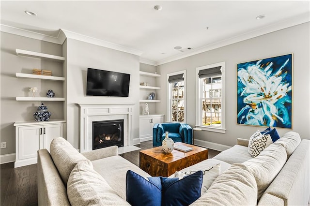 living area with dark wood-style floors, built in shelves, ornamental molding, and baseboards