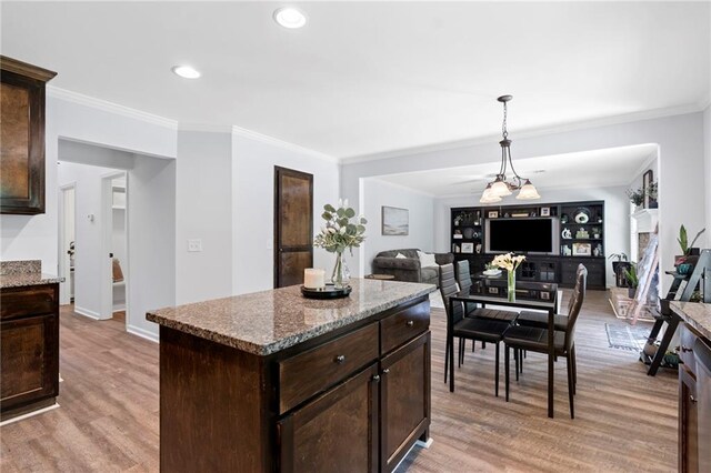 kitchen with dark brown cabinets, ornamental molding, and light wood-style flooring