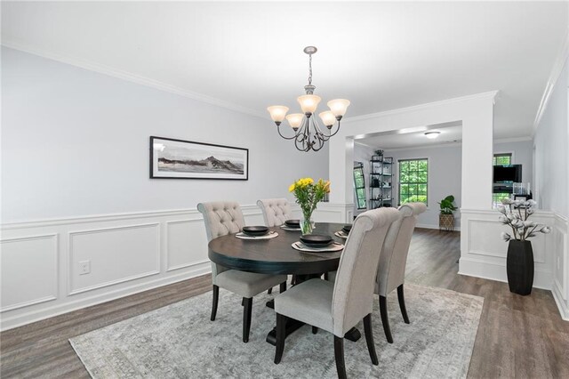 dining area with crown molding, wood finished floors, and a notable chandelier
