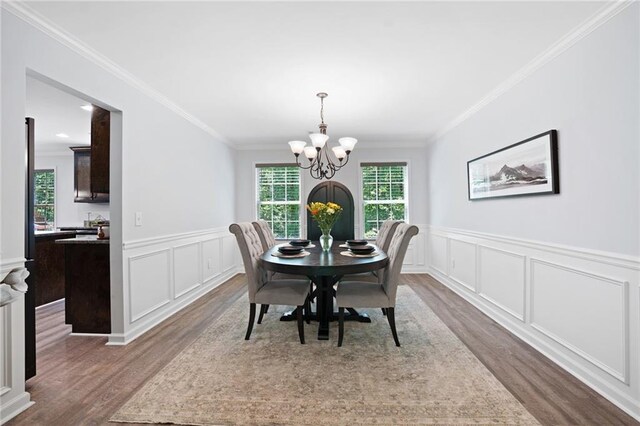 dining area featuring a notable chandelier, dark wood finished floors, and a healthy amount of sunlight