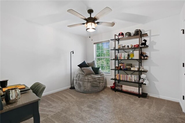 carpeted office with baseboards and a ceiling fan