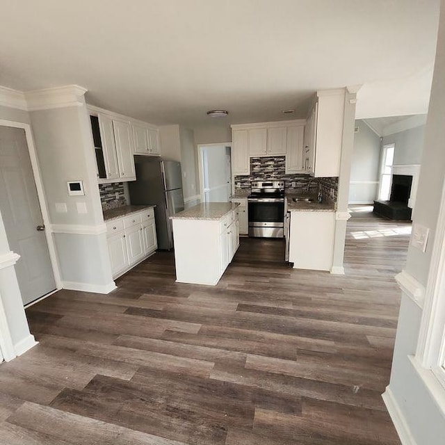 kitchen with stainless steel appliances, dark wood-type flooring, sink, and white cabinetry