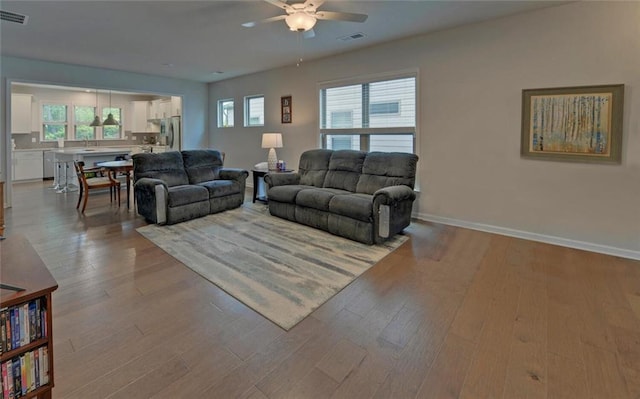 6003 Rollingwood Way, Hoschton, GA 30548 - living room featuring a ceiling fan, healthy amount of natural light, and wood finished floors