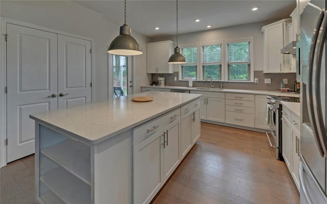 6003 Rollingwood Way, Hoschton, GA 30548 - kitchen with under cabinet range hood, stainless steel appliances, white cabinets, decorative backsplash, and recessed lighting