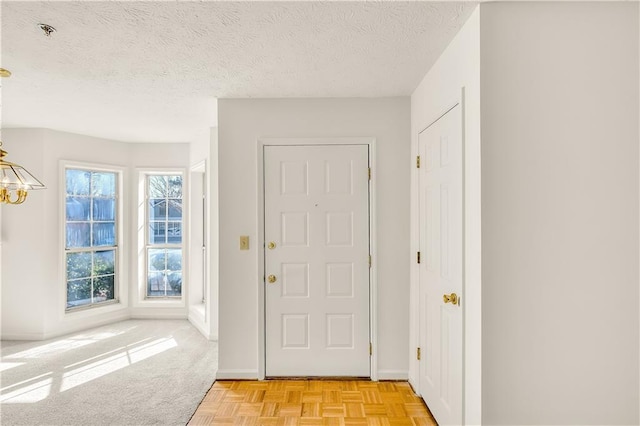 foyer featuring light parquet flooring and a textured ceiling