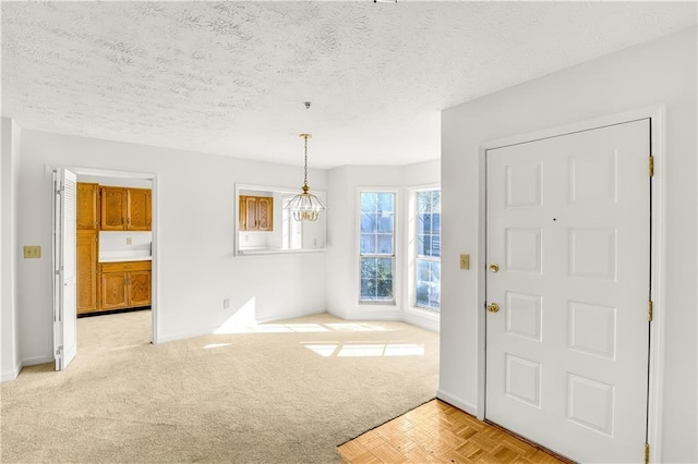 carpeted entrance foyer with a textured ceiling