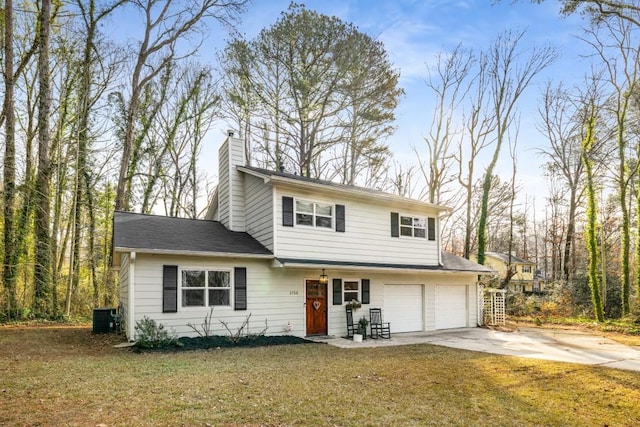 view of property featuring a front yard, central AC unit, and a garage