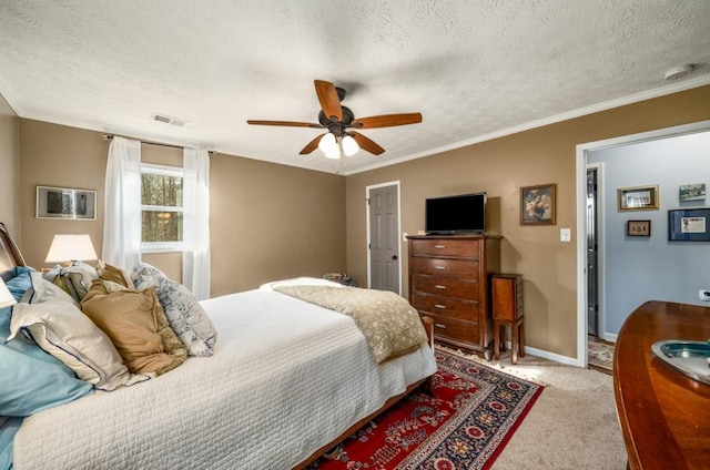 bedroom featuring a textured ceiling, ceiling fan, crown molding, and light colored carpet