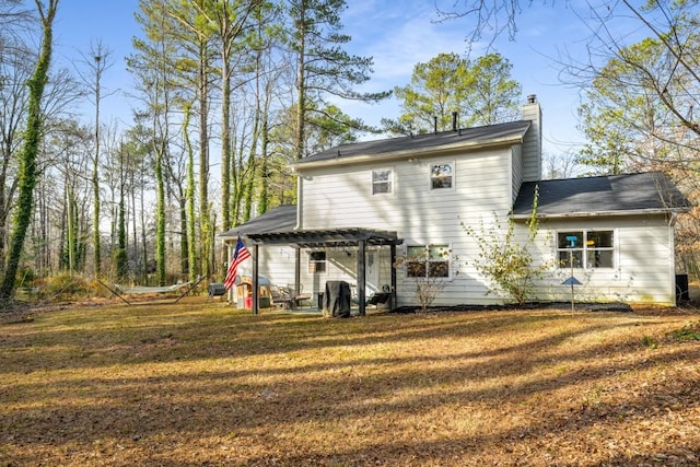 rear view of house featuring a yard and a pergola