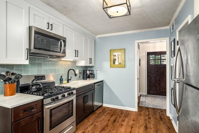 kitchen featuring tasteful backsplash, stainless steel appliances, dark brown cabinets, and white cabinetry