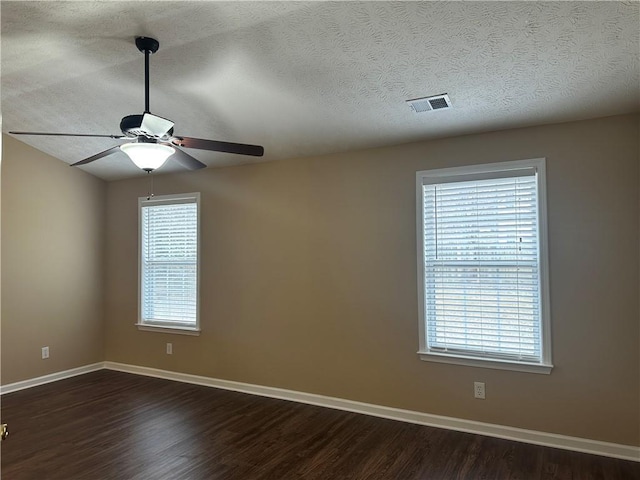 spare room featuring visible vents, baseboards, a textured ceiling, and dark wood finished floors