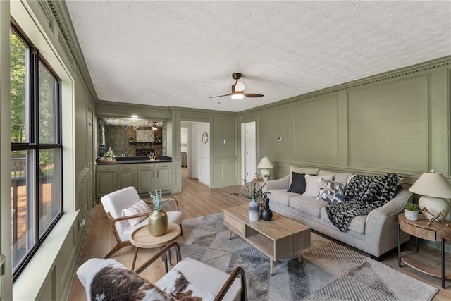 5759 Albans Way, Lithonia, GA 30058 - living area with a decorative wall, light wood-style floors, a textured ceiling, and ceiling fan