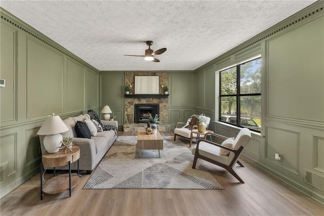 5759 Albans Way, Lithonia, GA 30058 - living room featuring a decorative wall, wood finished floors, a ceiling fan, and a fireplace