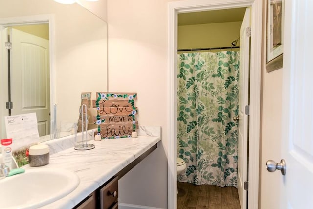 bathroom featuring curtained shower, toilet, vanity, and hardwood / wood-style flooring