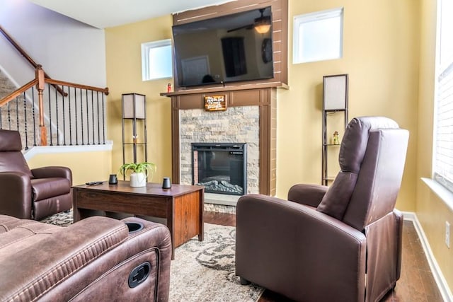 living room featuring hardwood / wood-style flooring and a stone fireplace