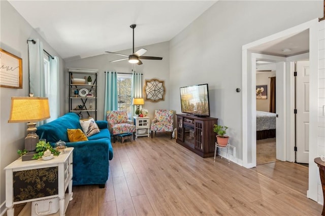 living room with ceiling fan, lofted ceiling, and light hardwood / wood-style floors