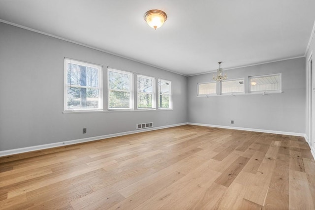 unfurnished room featuring a notable chandelier, ornamental molding, and light hardwood / wood-style floors