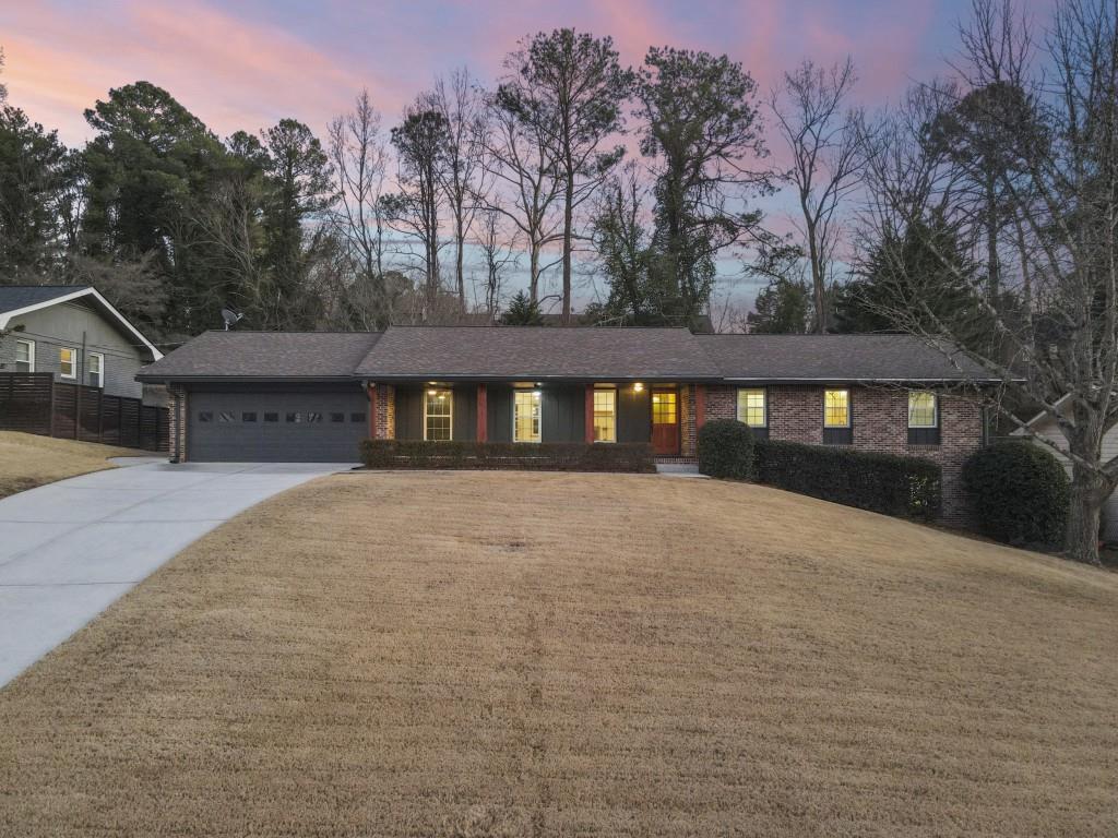 ranch-style house featuring a garage and a lawn