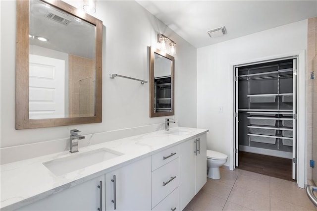 bathroom with tile patterned floors, a sink, double vanity, and visible vents