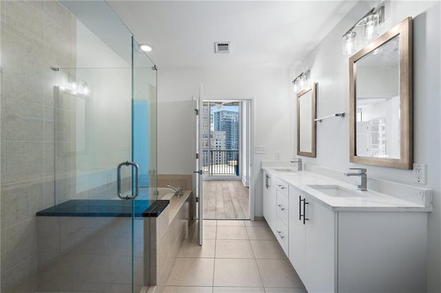 bathroom featuring visible vents, a sink, tile patterned flooring, and a shower stall