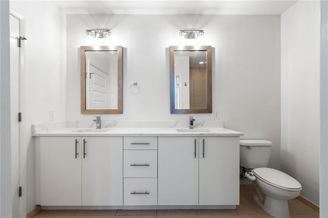 full bathroom with double vanity, a sink, toilet, and tile patterned floors