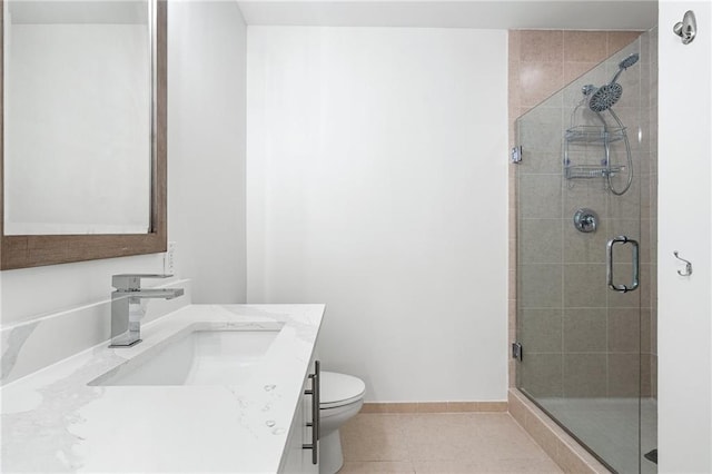 bathroom with a stall shower, toilet, vanity, tile patterned flooring, and baseboards