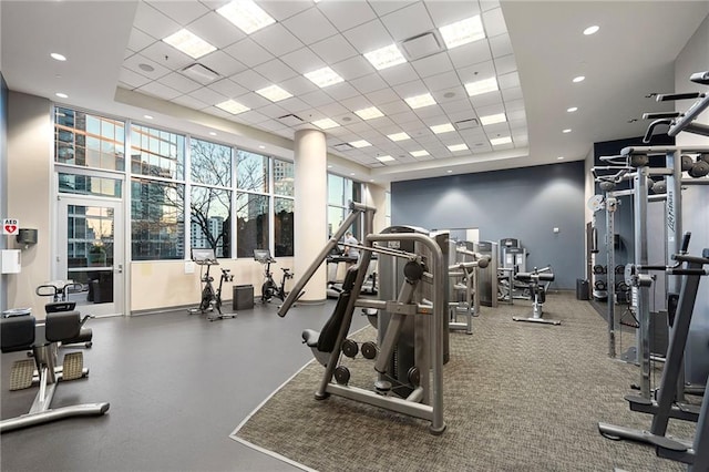 workout area featuring visible vents, a paneled ceiling, and a raised ceiling