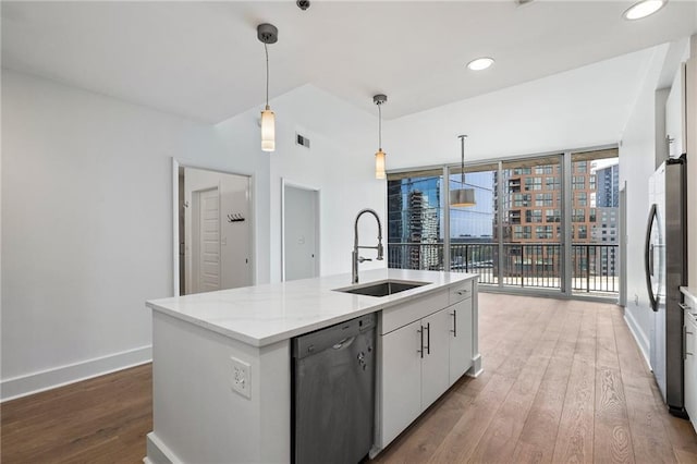 kitchen with baseboards, a sink, dishwashing machine, and wood finished floors