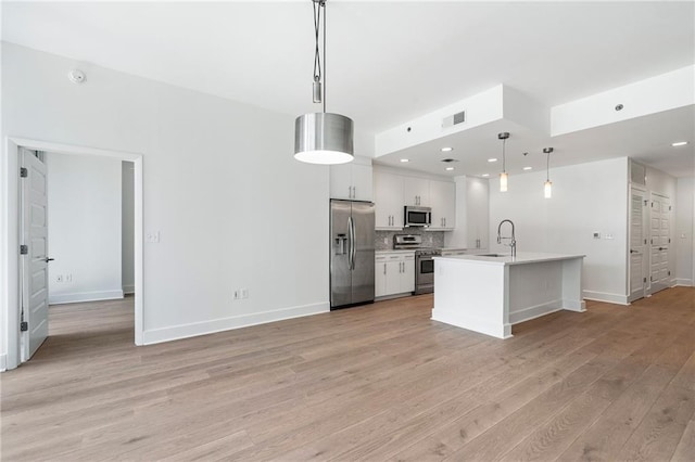 kitchen featuring light countertops, visible vents, appliances with stainless steel finishes, a sink, and light wood-type flooring