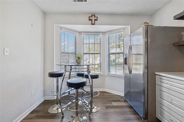 dining area featuring a healthy amount of sunlight and dark wood-type flooring