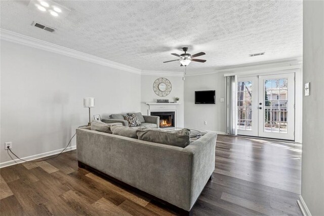 living room featuring ornamental molding, dark hardwood / wood-style floors, a textured ceiling, and french doors