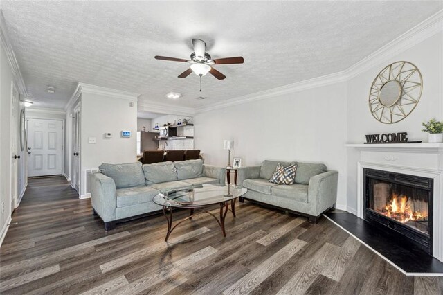 living room with crown molding, dark wood-type flooring, and a textured ceiling