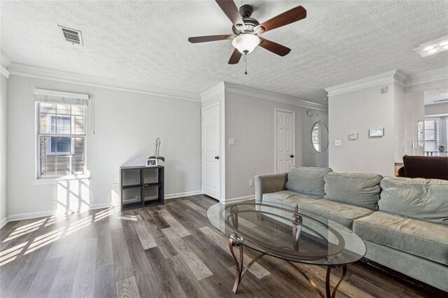 living room featuring crown molding, ceiling fan, dark hardwood / wood-style floors, and a textured ceiling