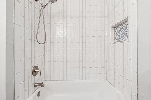 bathroom featuring tiled shower / bath