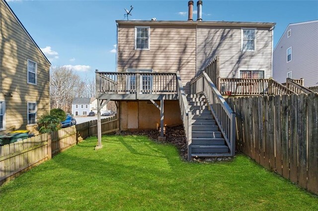 back of house featuring a wooden deck and a yard