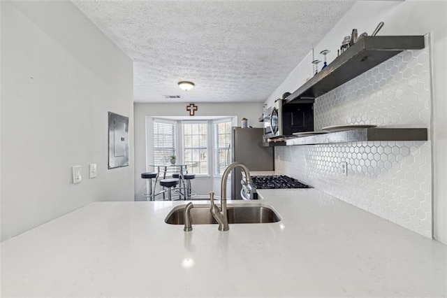 kitchen featuring stainless steel appliances, sink, and a textured ceiling