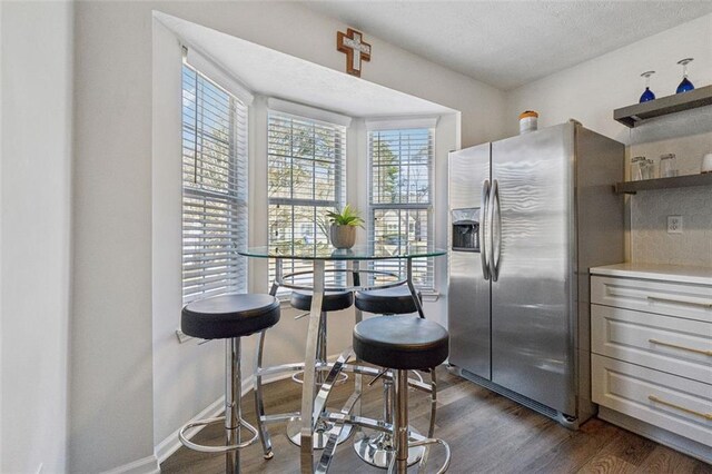 kitchen with tasteful backsplash, dark hardwood / wood-style floors, and stainless steel fridge