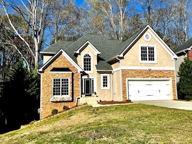 front facade featuring a front lawn and a garage