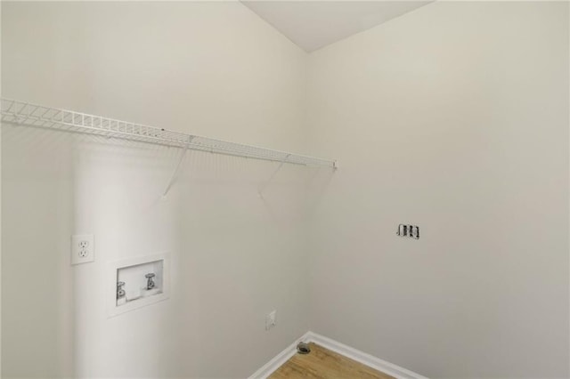 laundry area featuring washer hookup, laundry area, light wood-style flooring, and baseboards