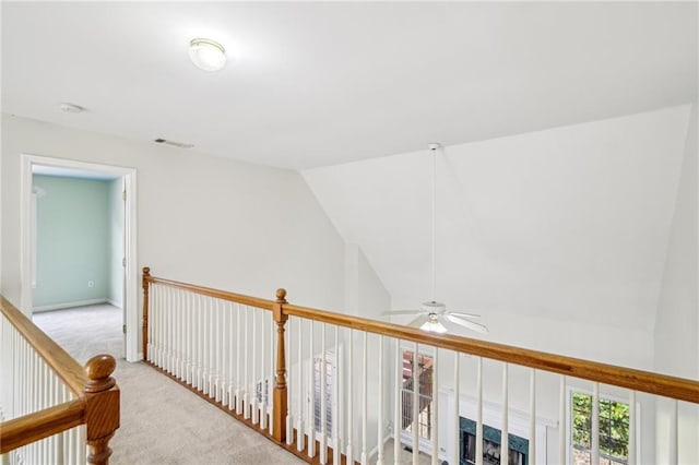 hall featuring lofted ceiling, carpet, visible vents, and baseboards