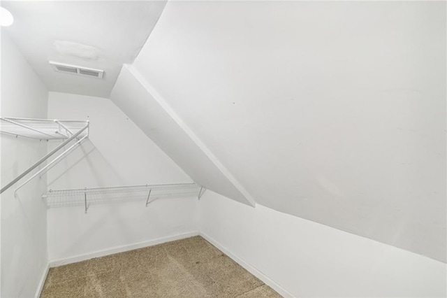 spacious closet featuring lofted ceiling, carpet, and visible vents