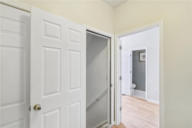 corridor with light wood finished floors and baseboards