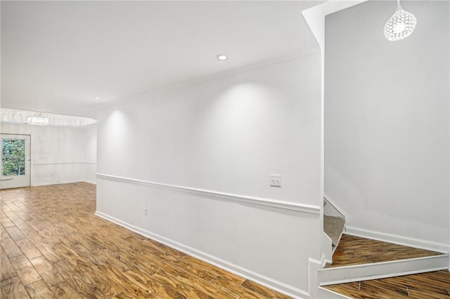 corridor featuring recessed lighting, stairway, baseboards, and wood finished floors