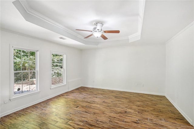 unfurnished room featuring dark wood-style floors, a raised ceiling, visible vents, and crown molding