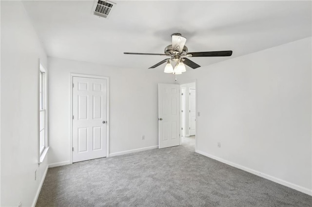 unfurnished bedroom with carpet floors, baseboards, visible vents, and ceiling fan